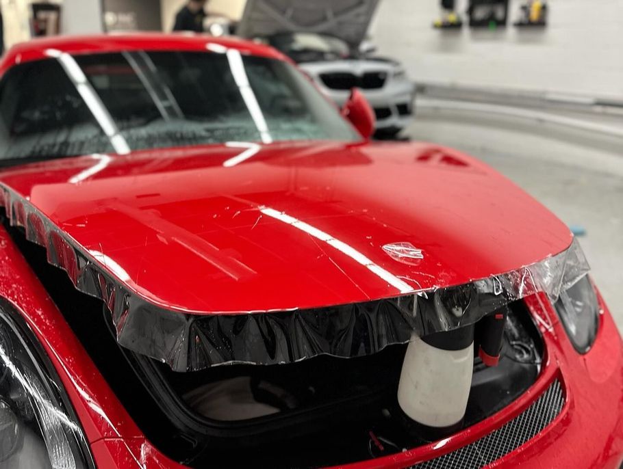 A gray sports car is parked in a showroom.