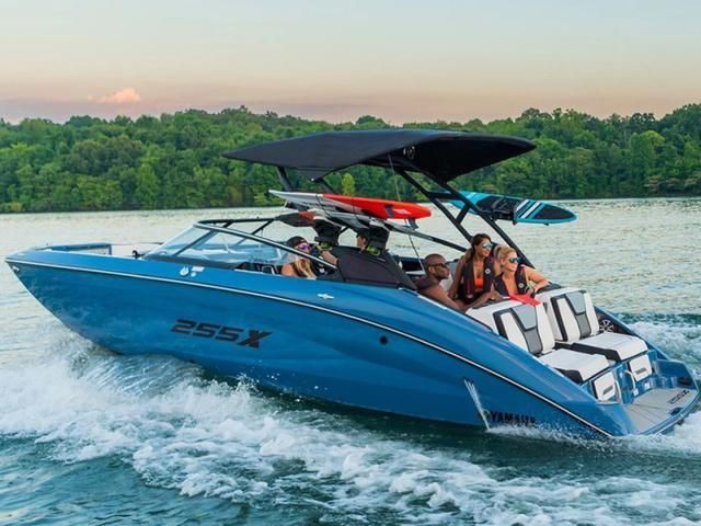 A group of people are riding a blue boat on a lake.