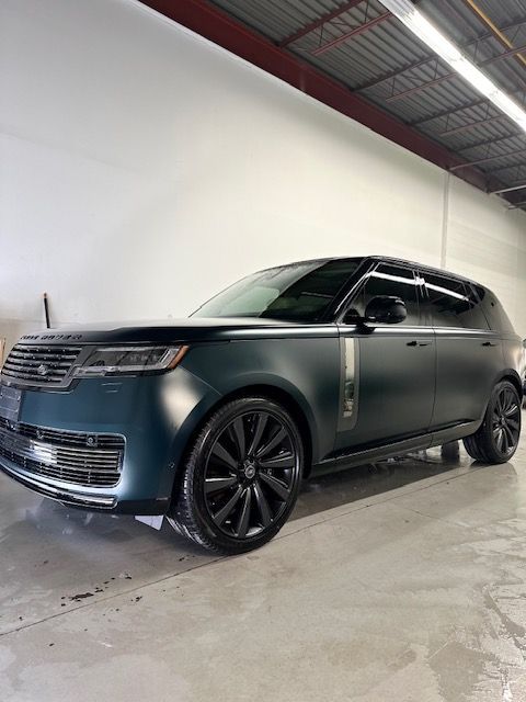 A black range rover is parked in a garage.