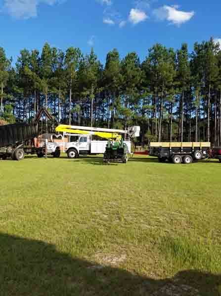 A truck with a crane on top of it is parked in a grassy field.