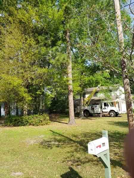 A white truck is parked in front of a house next to a mailbox.