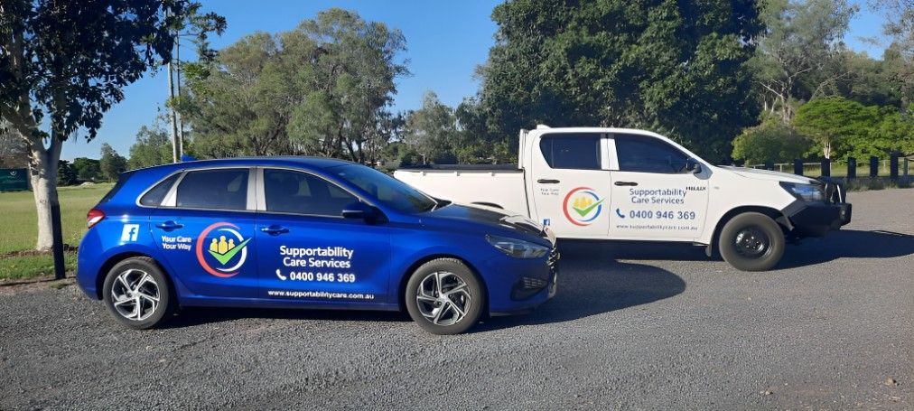 A Blue Car and a White Truck Are Parked Next to Each Other — Supportability Care Services in West Rockhampton, QLD