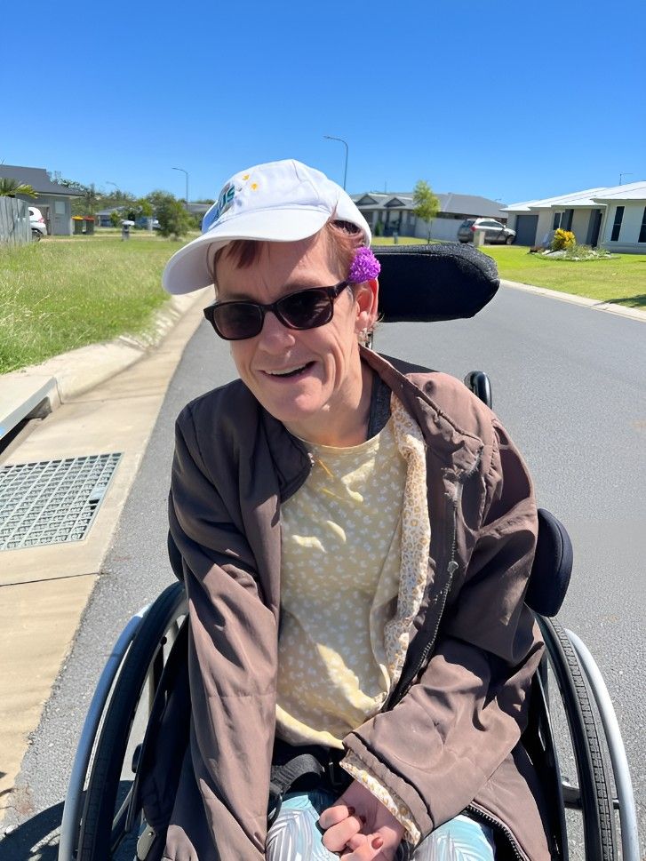 A Person in a Wheelchair is Wearing Sunglasses and a Hat — Supportability Care Services in West Rockhampton, QLD