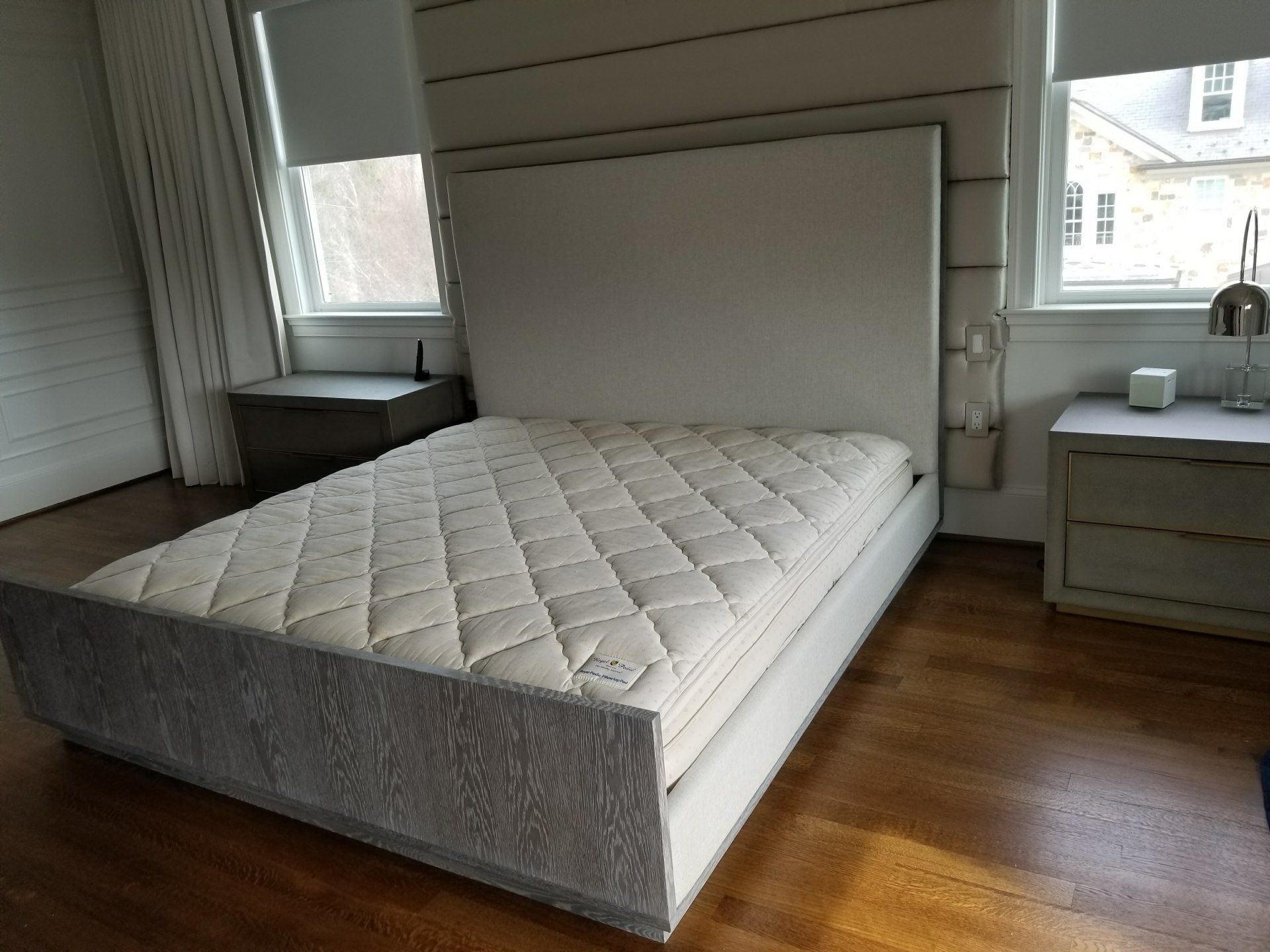 A bed with a mattress on it in a bedroom next to a window.