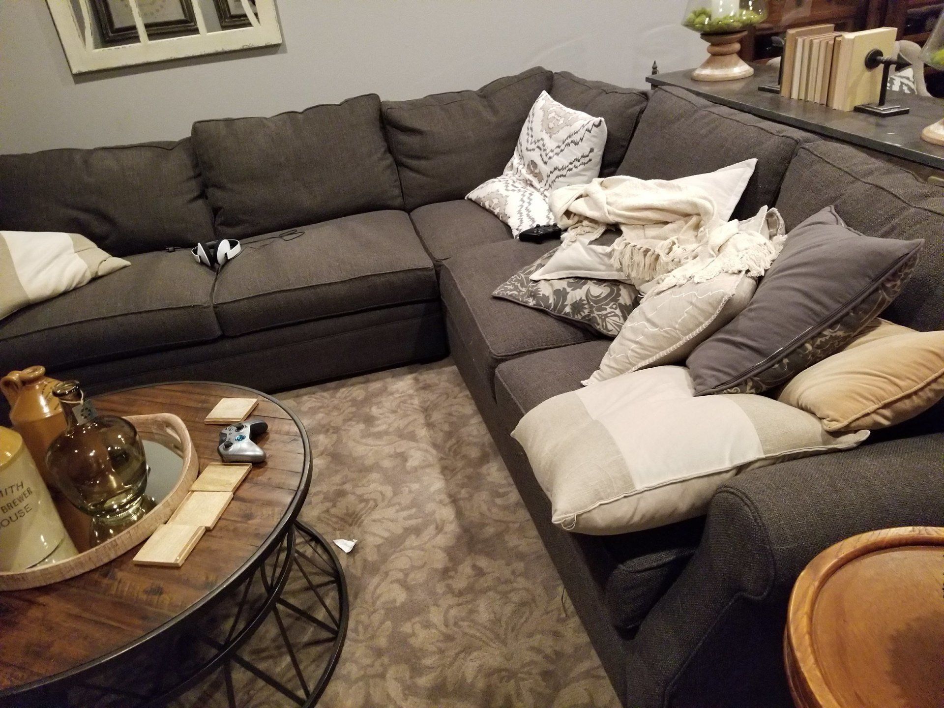 grey cloth corner couch with white pillows and wooden coffee table by furniture assembly team