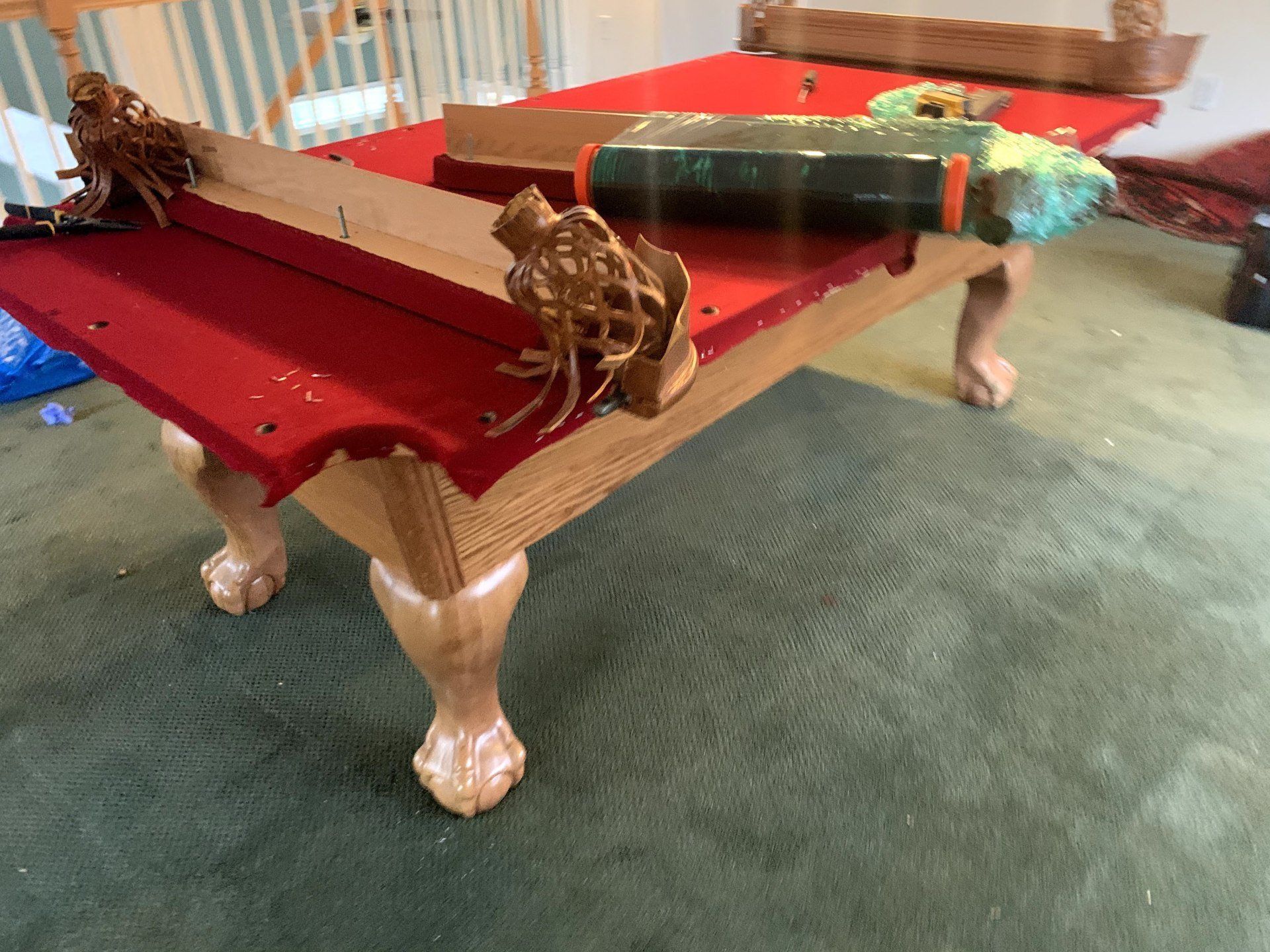 completed red velvet slate pool table with pool cues  by furniture assembly team