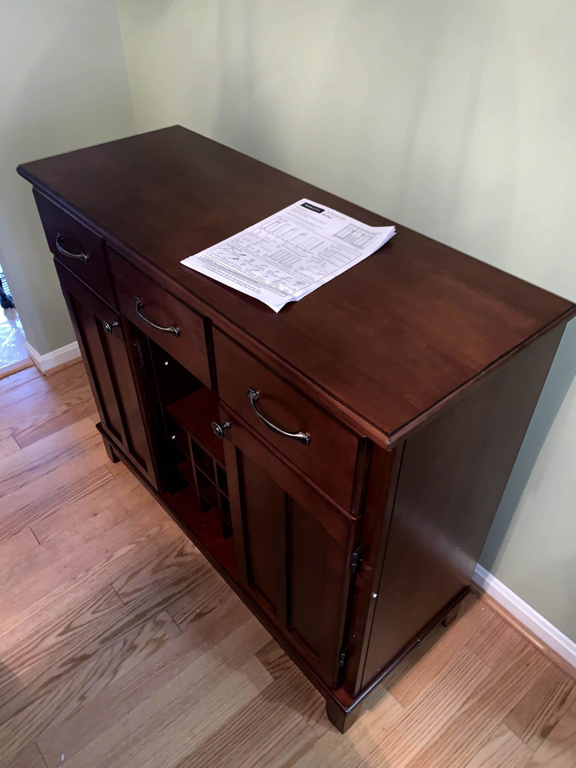 installed buffut wood decorated table with drawers on a light wooden floor by furniture assembly team