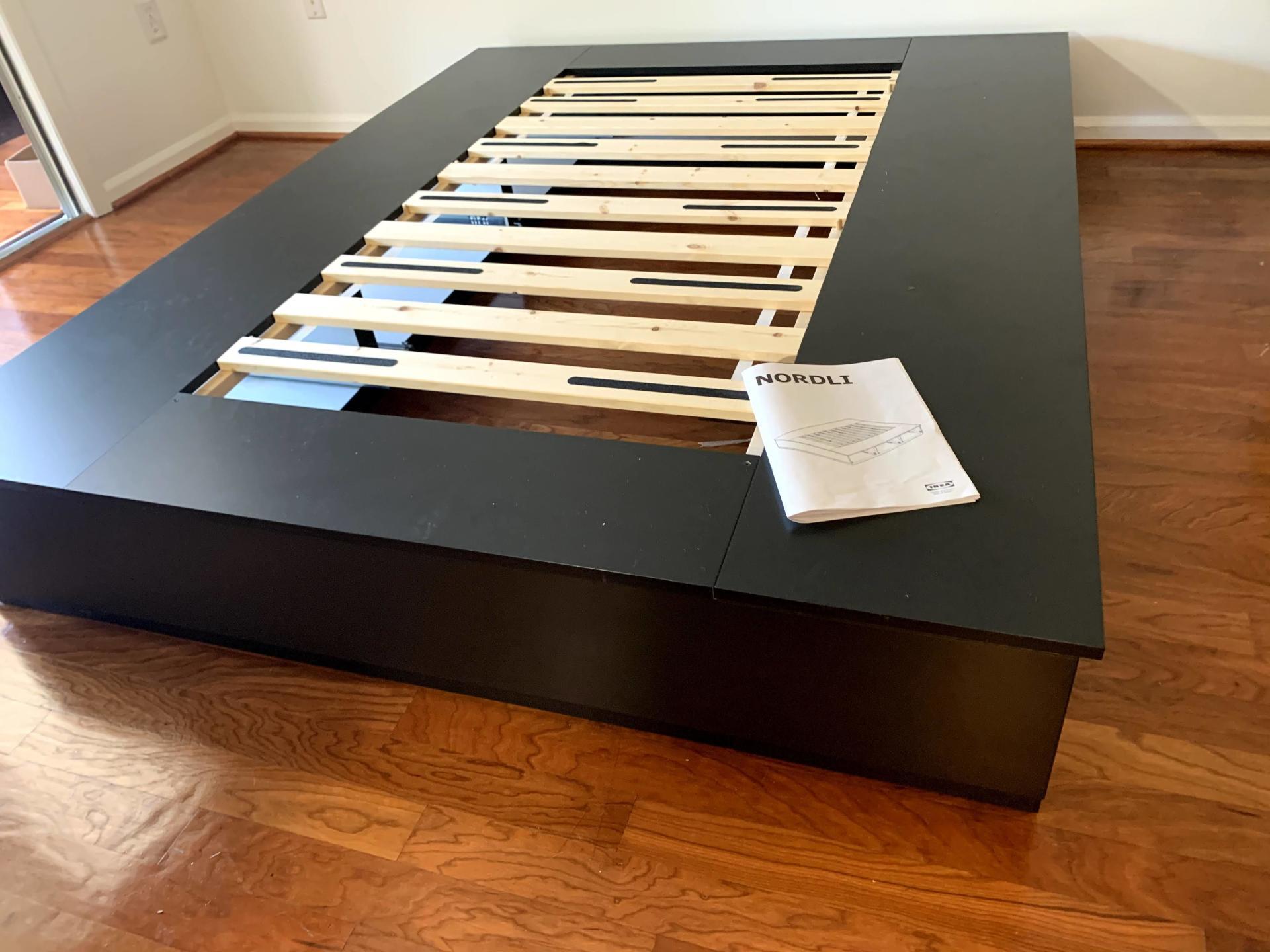 disassembled IKEA Nordli bed in black with a white by furniture assembly team