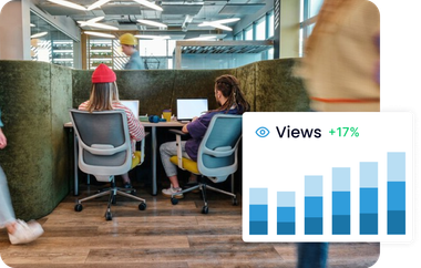 A group of people are sitting at desks in front of computers with a graphic showing the number of clics.
