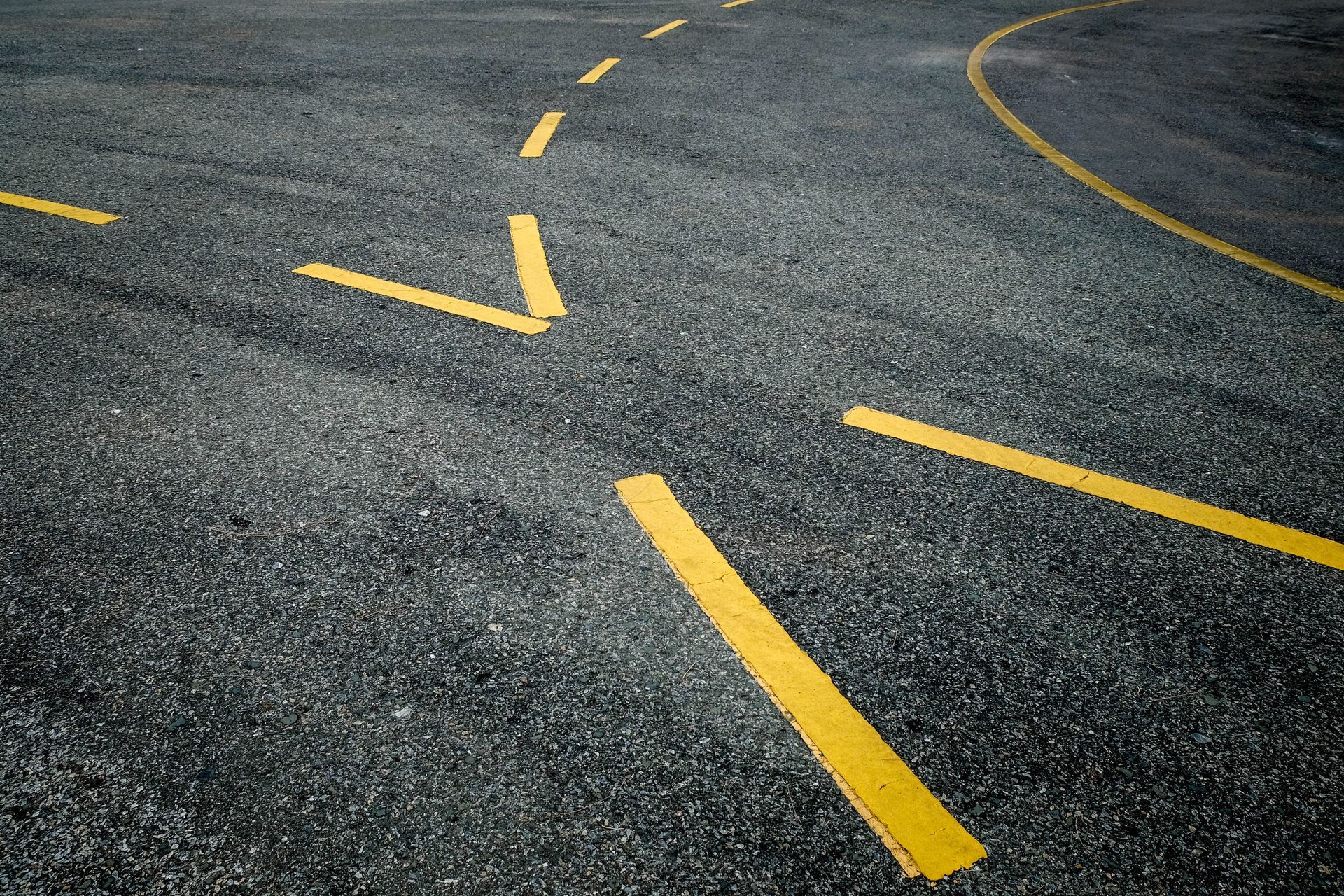 A close up of a road with yellow lines on it.