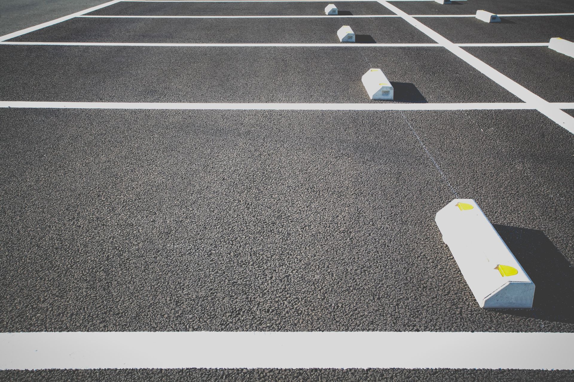 A parking lot with white lines and white blocks on the ground.