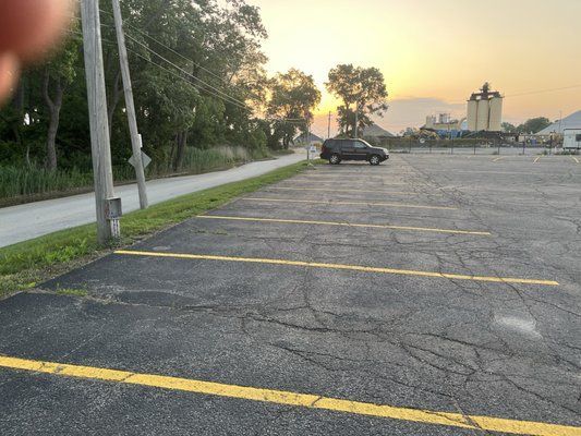 A car is parked in a parking lot at sunset.