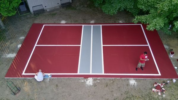 An aerial view of a tennis court in a backyard