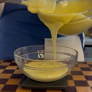 Divisione dell'impasto base in due ciotole separate per creare il plumcake bicolore.