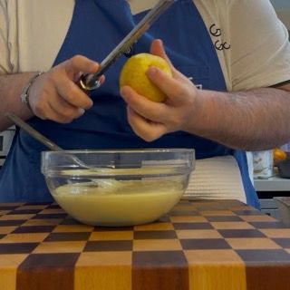 Aggiunta della scorza di limone grattugiata all'impasto bianco per il plumcake fatto in casa morbido.