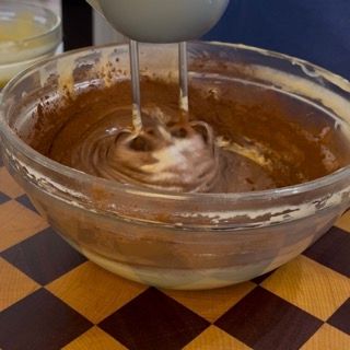 Mescolamento dell'impasto scuro con la frusta manuale per ottenere il gusto cioccolato