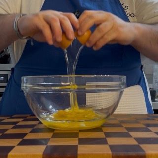 Apertura delle uova nella ciotola con farina e zucchero per l'impasto base per torte.