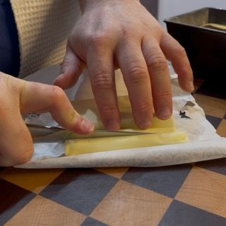 Divisione del panetto di burro freddo in due stecchette sottili.