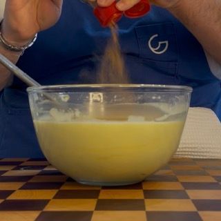 Aggiunta della cannella in polvere all'impasto base universale per dolci.