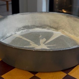 Stampo da 26cm imburrato e infarinato con foglio di carta forno sulla base.