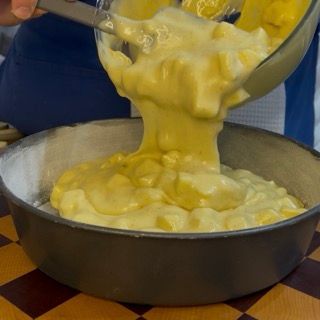 Versamento dell'impasto alle mele soffice nello stampo tortiera.