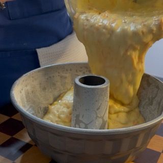 Versamento dell'impasto alle carote nello stampo ciambella e livellamento.