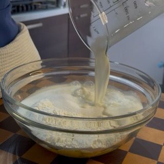 Aggiunta del latte intero e dell'olio di semi all'impasto base per torte in ciotola.