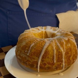 Preparazione e distribuzione della glassa di zucchero a velo e limone sulla torta.