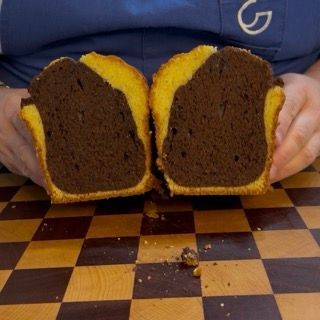 Taglio di una fetta di plumcake marmorizzato soffice per la colazione, realizzato con l'impasto furbo.