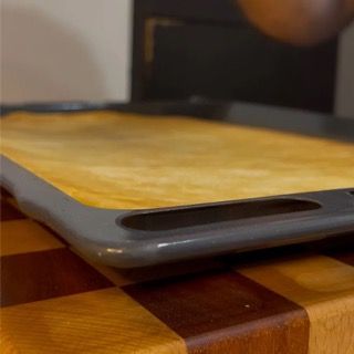 Un tagliere è appoggiato su un tagliere di legno.