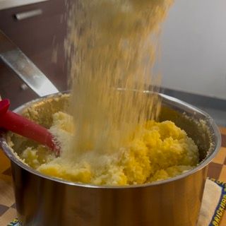 La farina viene versata in una pentola con una spatola