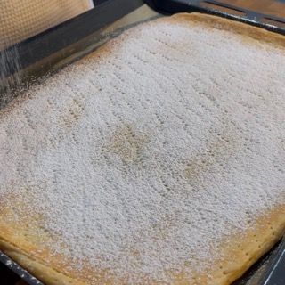 Una padella con del cibo ricoperto di zucchero a velo.