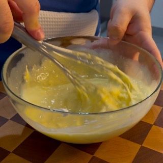 Una persona sta mescolando qualcosa in una ciotola con una frusta