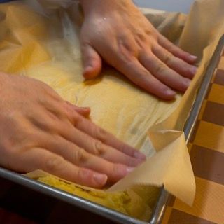 Una persona sta mettendo le mani su un pezzo di carta oleata