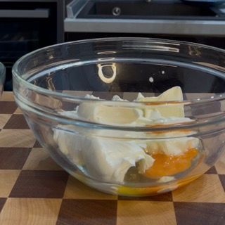 Una ciotola di vetro piena di cibo su un tavolo a scacchi