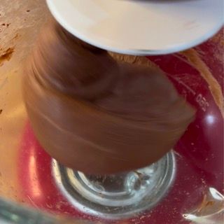 Un primo piano di un mixer con del cioccolato che viene mescolato al suo interno