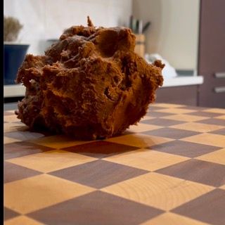 Un pezzo di pasta è appoggiato su un tagliere a scacchi