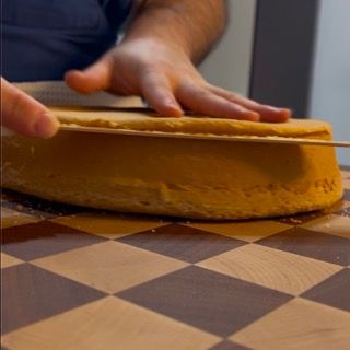 Una persona sta tagliando una torta su una scacchiera