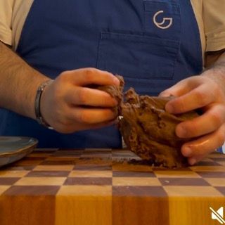 Un uomo che indossa un grembiule con la lettera g sopra