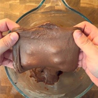 Una persona tiene in mano un pezzo di cioccolato