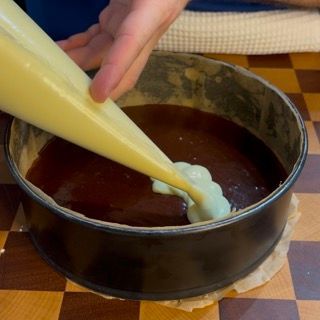 Una persona sta versando del liquido in una padella su un tavolo a scacchi