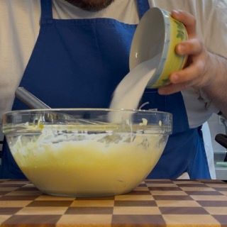 Una persona che versa del liquido in una ciotola di cibo