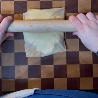 Una persona sta stendendo un pezzo di pasta con un mattarello