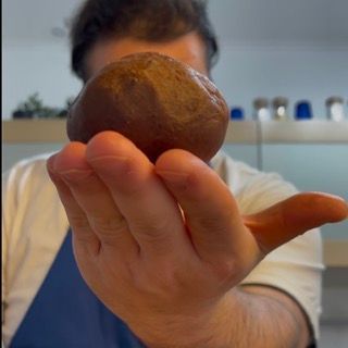 Un uomo tiene in mano una palla marrone