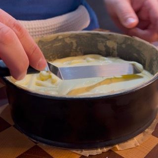 Una persona tiene una spatola sopra una padella di cibo