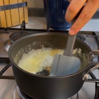 Una persona sta mescolando qualcosa in una pentola con una spatola