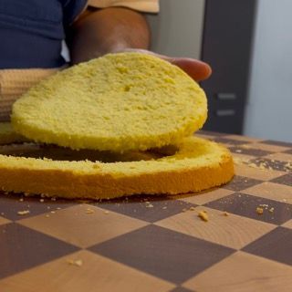 Una persona sta tagliando una fetta di torta su una scacchiera