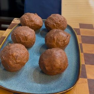 Un piatto blu sormontato da palline di cioccolato su una tovaglia a quadri