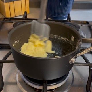 Una pentola di burro viene mescolata con una spatola su un fornello