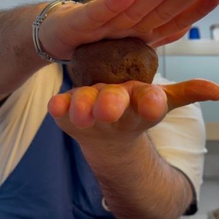 Un uomo tiene in mano una palla marrone